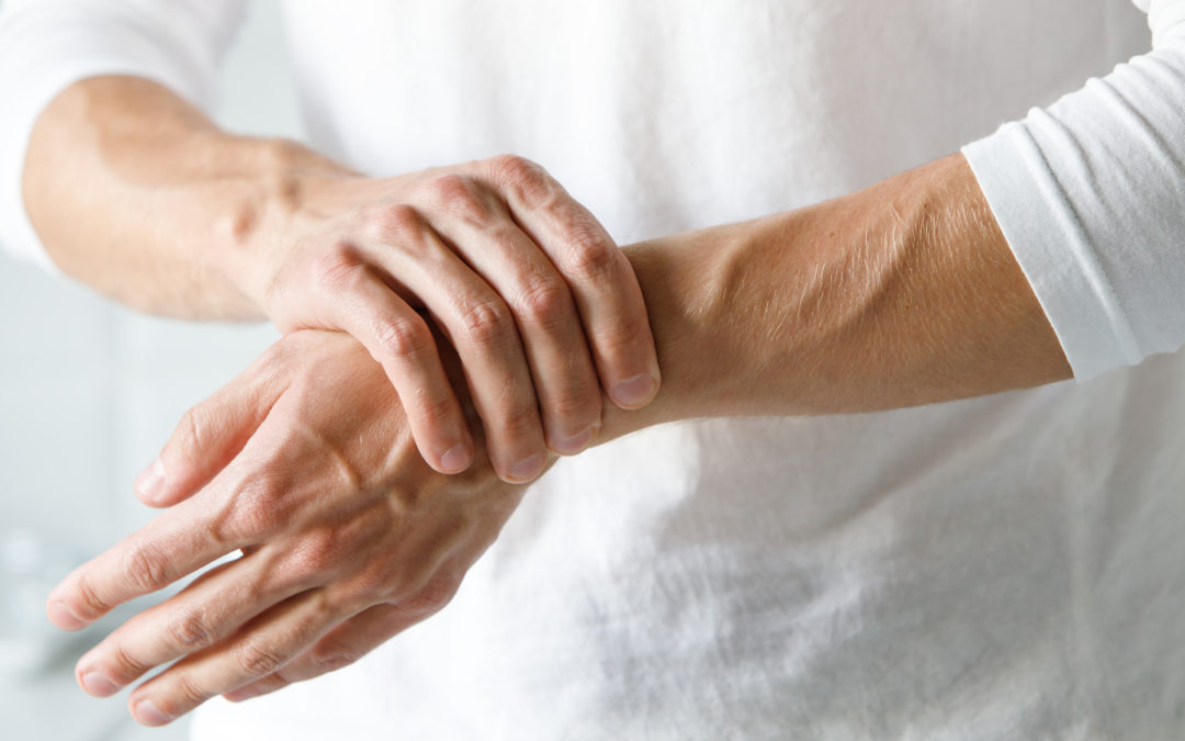 male arms holding his painful wrist caused by prolonged work on